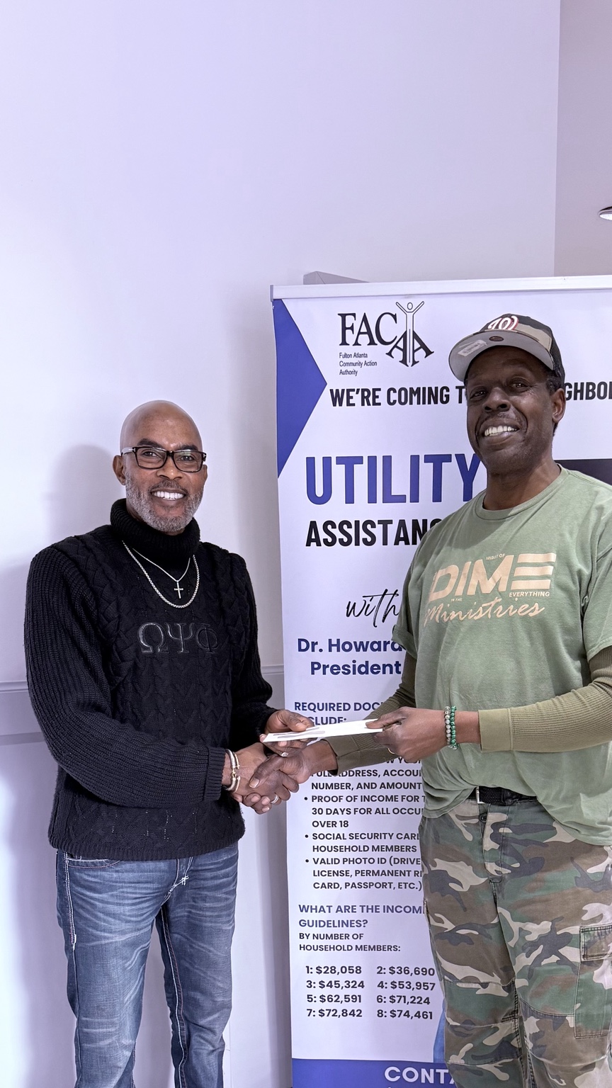 Dr. Grant presenting utility assistance to a community member at an agency event