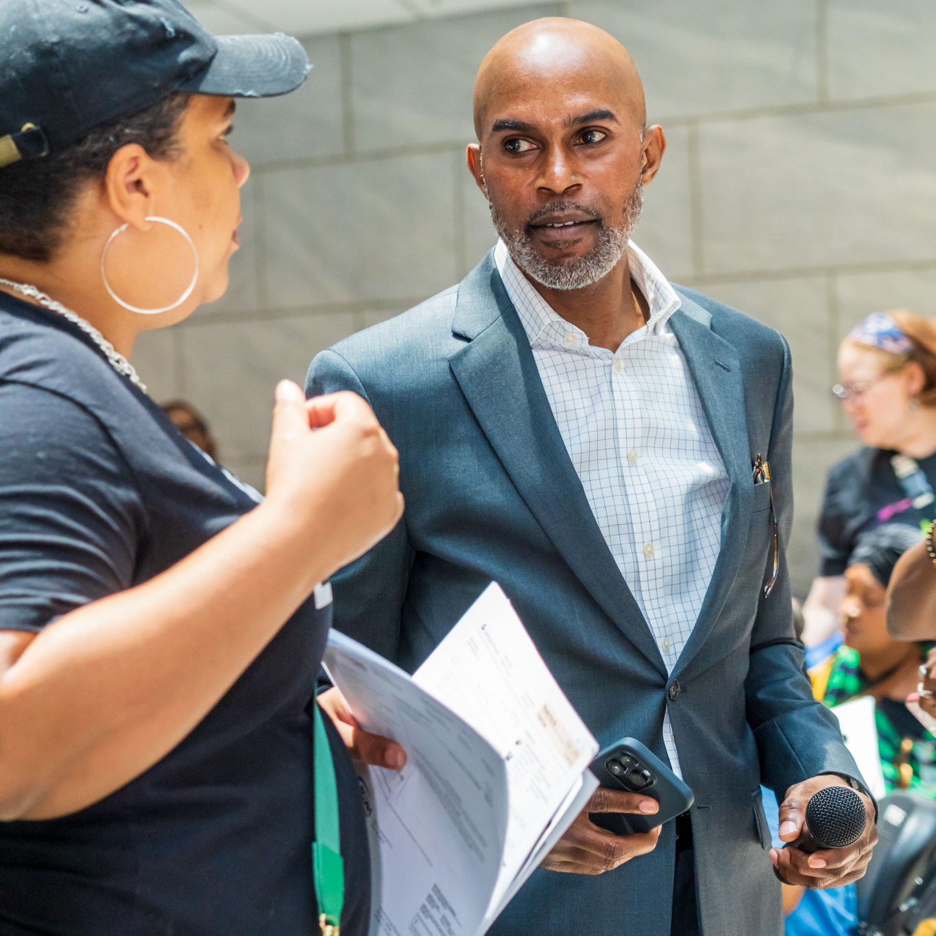 Dr. Grant in conversation with an attendee at a Community Action event