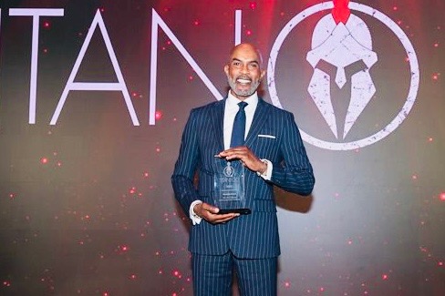 Dr. Grant holding an award on stage at a recognition ceremony