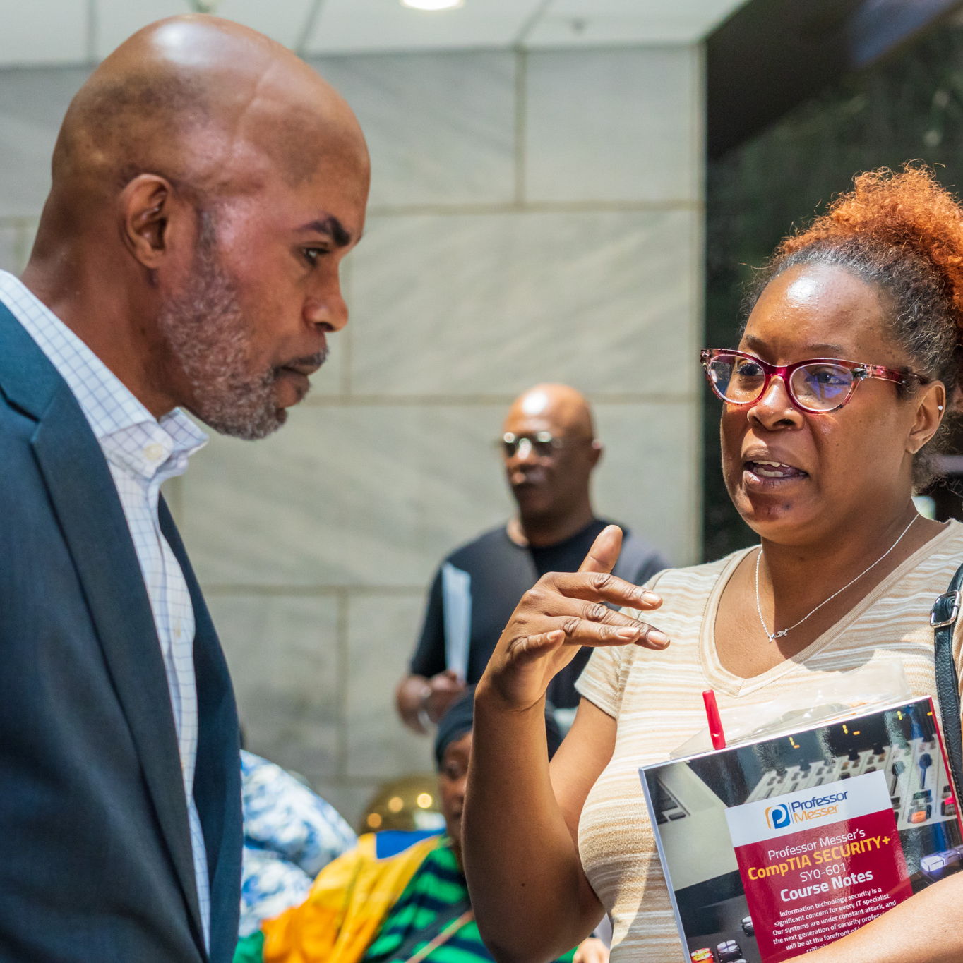 Dr. Grant listening closely to a community member at an outreach event
